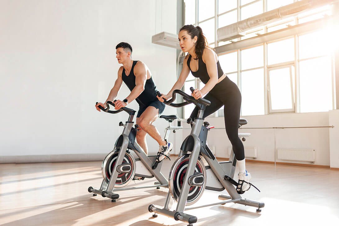 Two cyclists pedaling with a cadence sensor