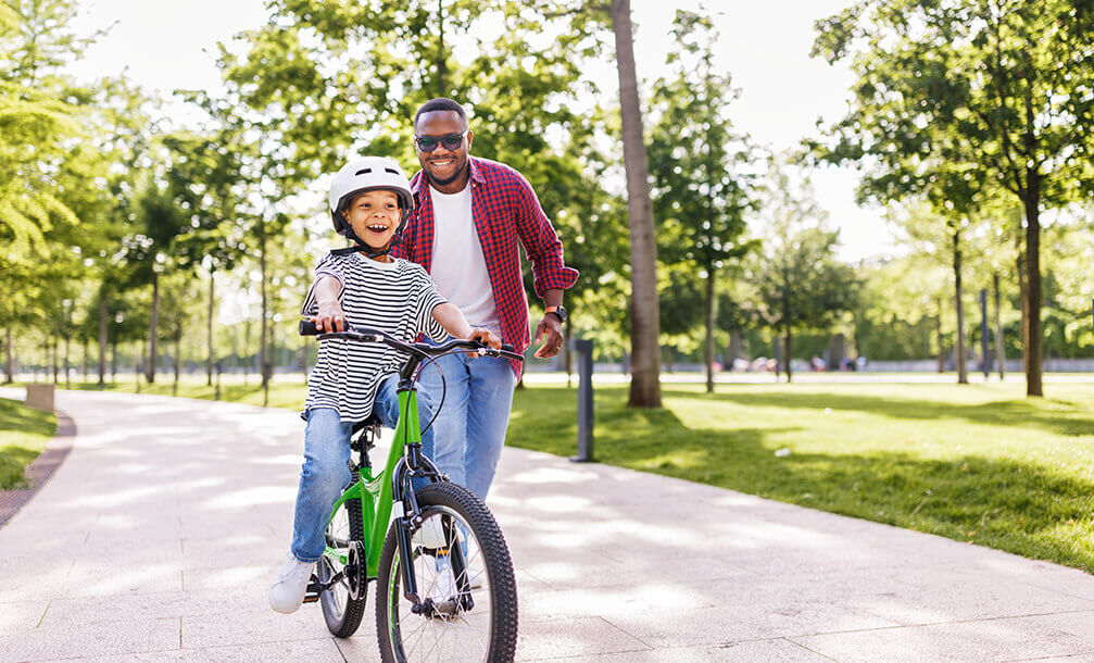 A father teaching his child how to ride a bicycle